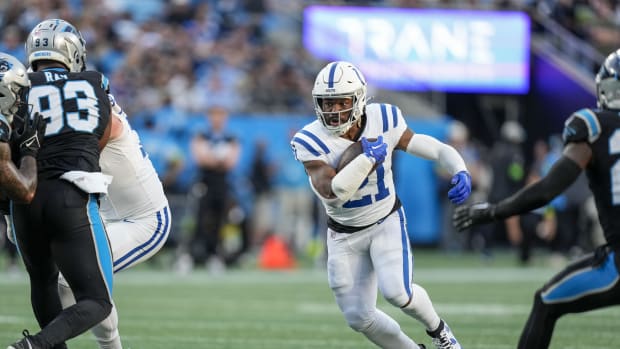 Nov 5, 2023; Charlotte, North Carolina, USA; Indianapolis Colts running back Zack Moss (21) runs through an opening defended by Carolina Panthers defensive tackle LaBryan Ray (93) during the first quarter at Bank of America Stadium. Mandatory Credit: Jim Dedmon-USA TODAY Sports  